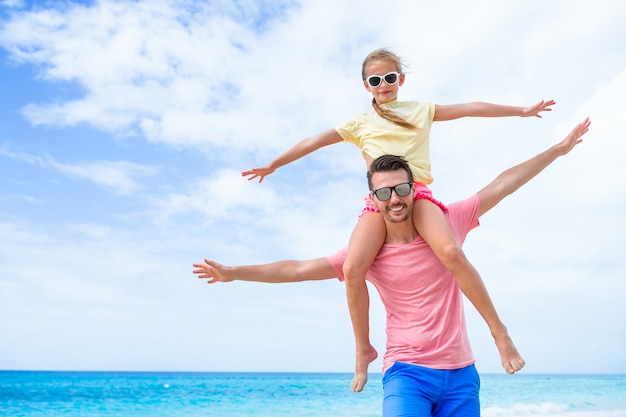 Bambina e papà felice divertendosi durante la vacanza della spiaggia