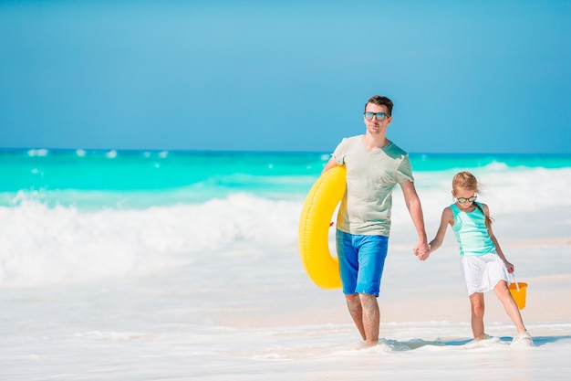 Bambina e papà felice divertendosi durante la vacanza della spiaggia