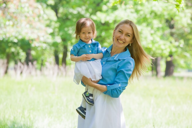 Bambina e sua madre con gli stessi vestiti per una passeggiata nella foresta. L'amore e la tenerezza della mamma