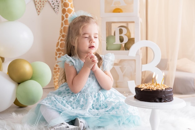 Bambina fa un desiderio e soffia candeline sulla torta di compleanno