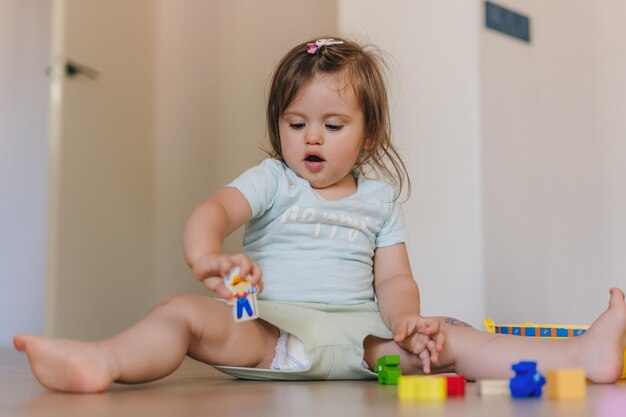 Bambina felice che costruisce qualcosa da mattoni e blocchi giocattolo colorati Giocare insieme godendosi il tempo libero