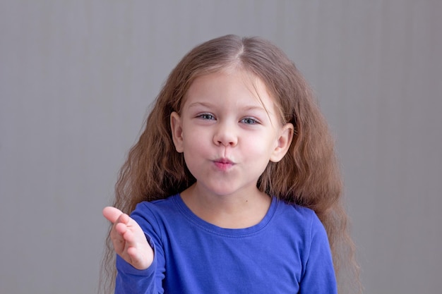 Bambina felice che fa bacio dell'aria