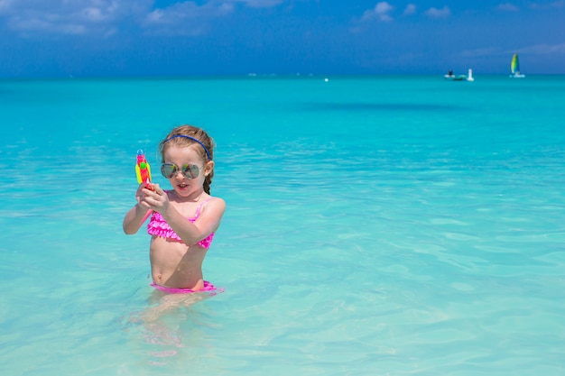 Bambina felice che gioca alla spiaggia durante la vacanza caraibica