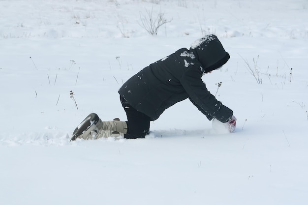 Bambina felice che gioca con gli outddor di neve in inverno in campagna