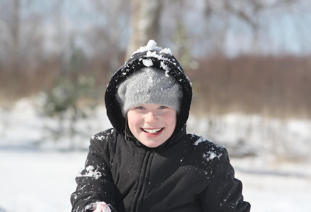 Bambina felice che gioca con gli outddor di neve in inverno in campagna