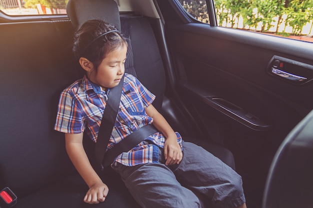 Bambina felice che indossa le cinture di sicurezza in auto