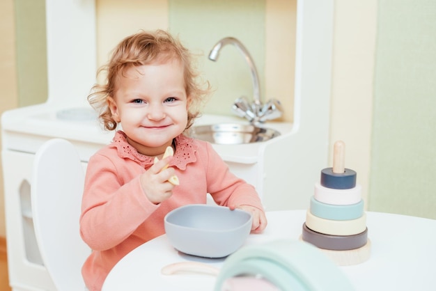 Bambina felice che mangia pasta all'asilo