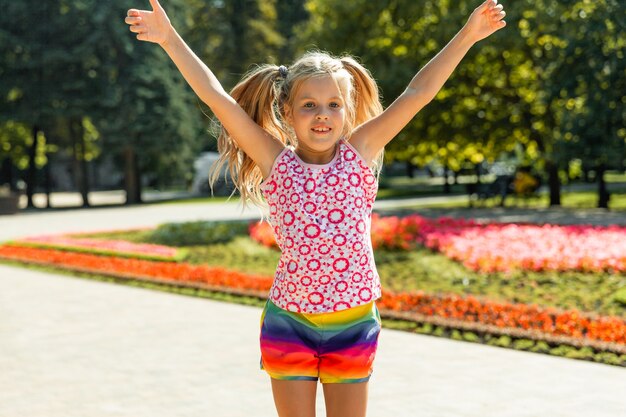 Bambina felice che salta nel parco. bambina che mangia il gelato e si diverte in città.