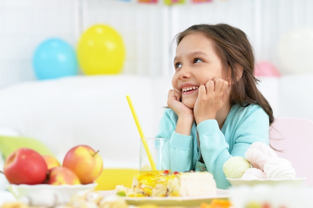 Bambina felice con la torta alla festa di compleanno