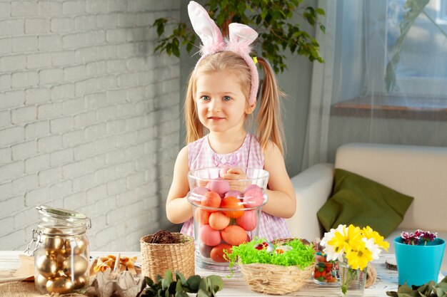 Bambina felice con le orecchie del coniglietto che si prepara per la festa di Pasqua