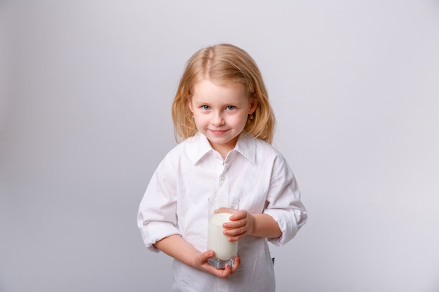 bambina felice con un bicchiere di latte