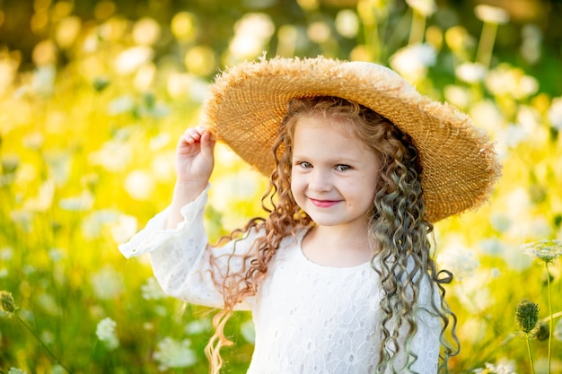 Bambina felice con un cappello nel campo