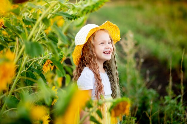 Bambina felice nel campo di girasoli