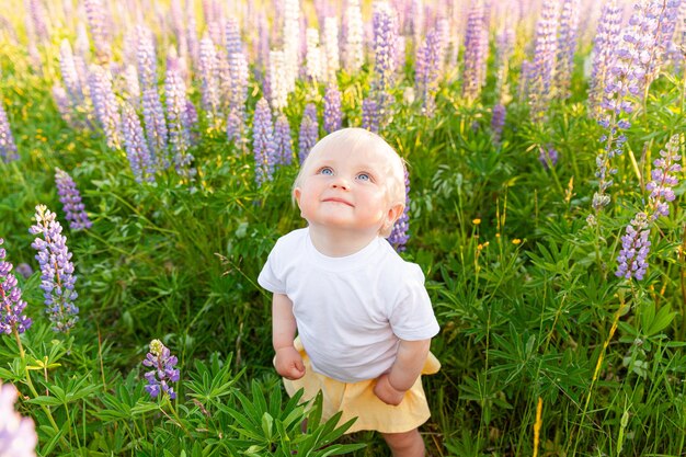 bambina felice sorridente all'aperto giovane bambina che riposa sul campo estivo con fiori selvatici in fiore