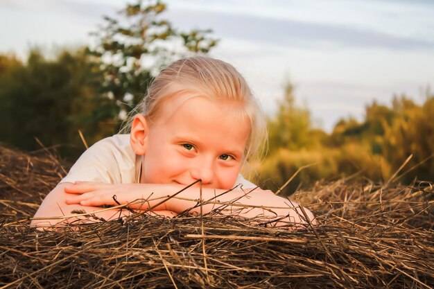 Bambina felice su un pagliaio in campagna