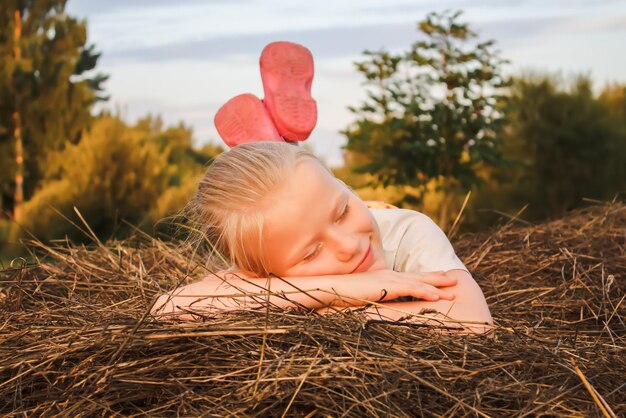 Bambina felice su un pagliaio in campagna