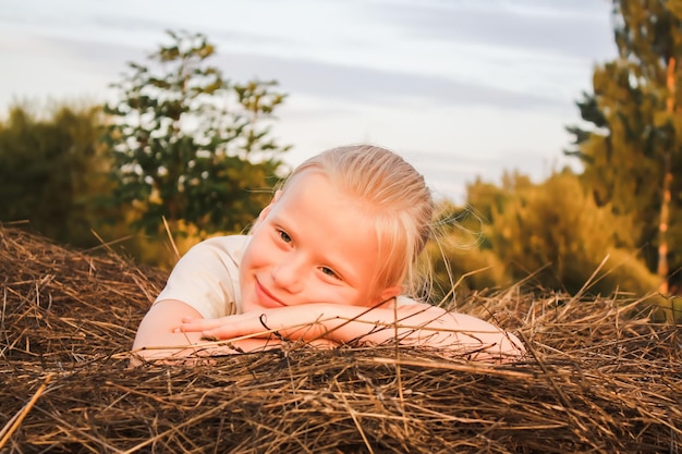 Bambina felice su un pagliaio in campagna