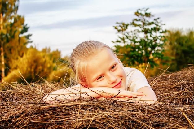 Bambina felice su un pagliaio in campagna