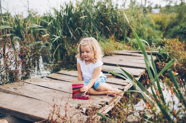 bambina felice su un ponte di legno