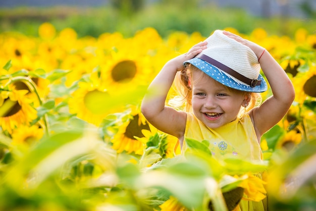 Bambina felice sul campo di girasoli in estate. bella bambina in girasoli