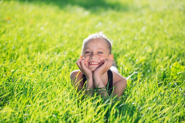 Bambina felice sveglia che si trova sull'erba