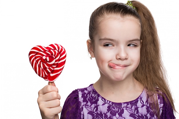 Bambina felice sveglia con il caucasian della lecca-lecca su fondo bianco isolato