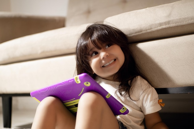Bambina felice utilizzando una tavoletta digitale