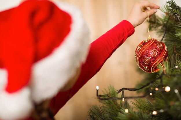 Bambina festiva che appende una decorazione di Natale