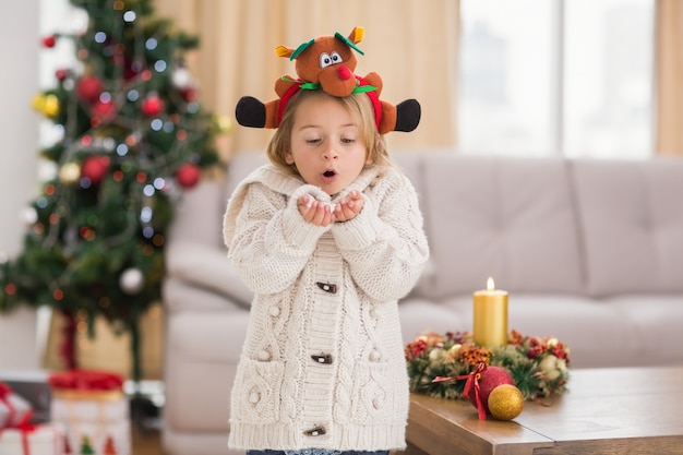 Bambina festiva che soffia sopra le mani