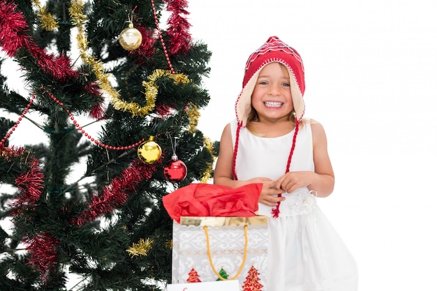 Bambina festiva che sorride alla macchina fotografica con i regali