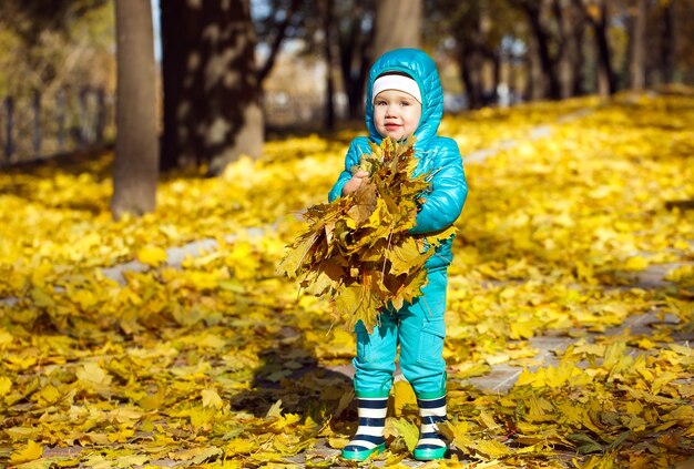 Bambina gettando foglie di autunno