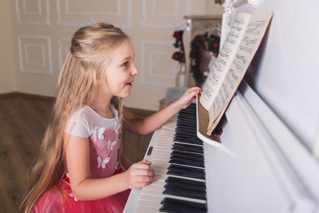 Bambina gioca al pianoforte in abito