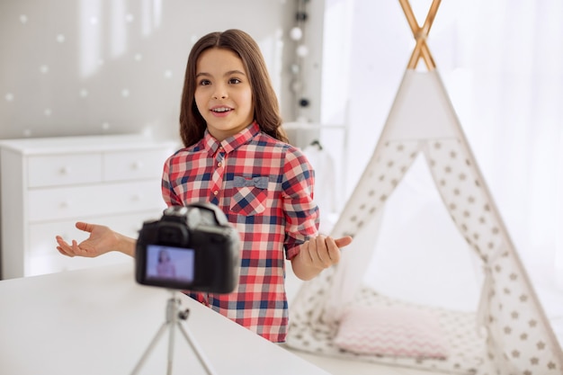 Bambina graziosa che cattura con il suo pubblico davanti alla telecamera