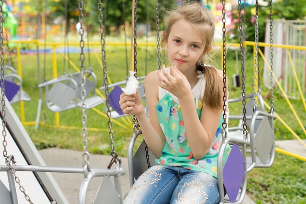 Bambina graziosa che mangia zucchero filato