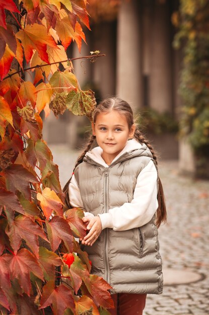 Bambina graziosa che riposa nel parco autunnale