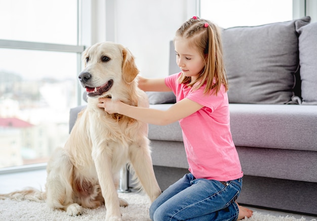 Bambina graziosa con il golden retriever