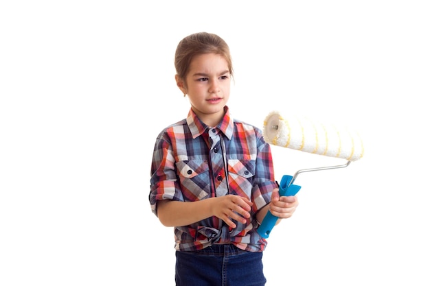 Bambina graziosa con la treccia lunga della castagna in camicia rossa del plaid che tiene i guanti arancioni in studio