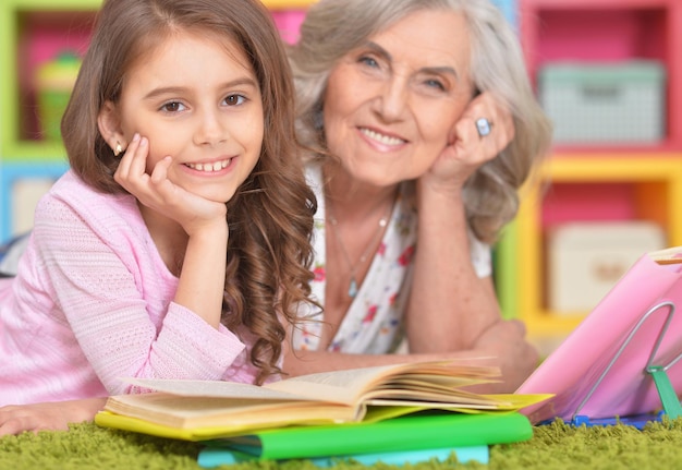 Bambina graziosa e sua nonna che fanno i compiti insieme