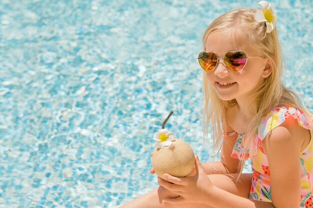 Bambina graziosa in piscina, vacanze estive.