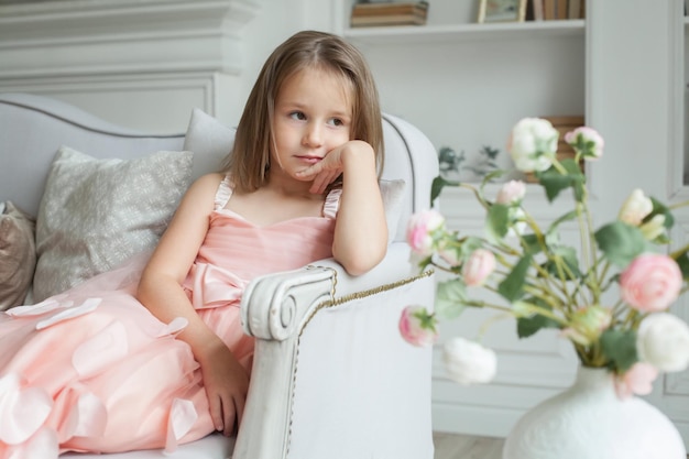 Bambina in abito rosa che riposa a casa