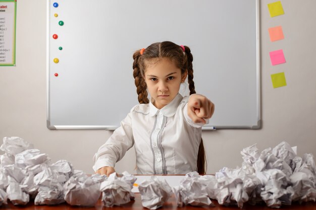 Bambina in aula che punta in avanti