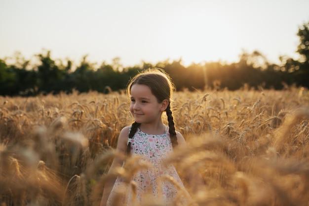 bambina in autunno campo di grano maturo dorato