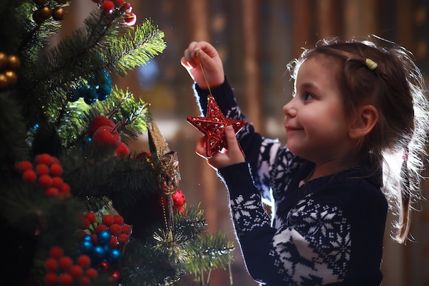 Bambina in cappello rosso in attesa di Babbo Natale. Buon e luminoso natale. Il bambino adorabile gode del natale. Il piccolo bambino della ragazza di Santa celebra il natale a casa.