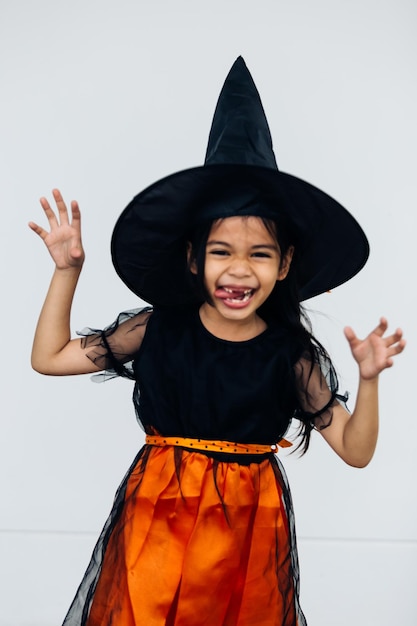 bambina in costume di halloween con cappello da strega su sfondo bianco