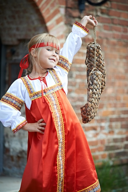 Bambina in costumi nazionali con rafia