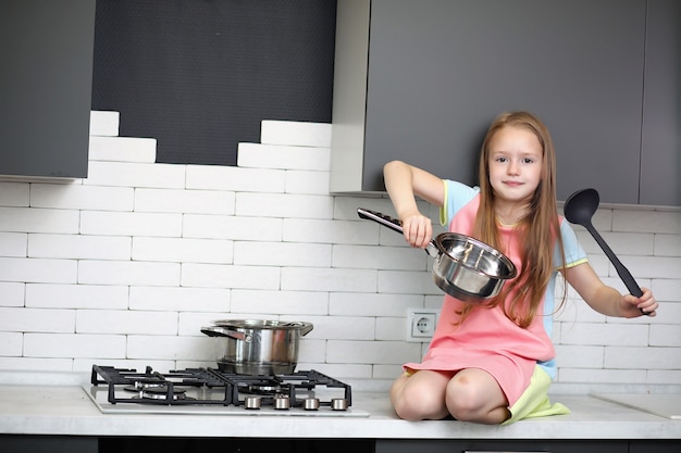 Bambina in cucina in posa davanti alla telecamera