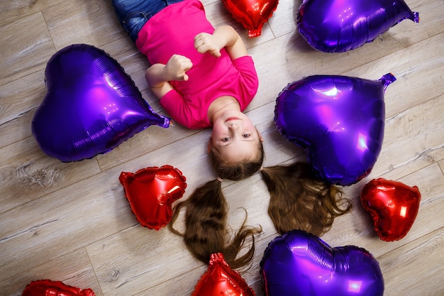 Bambina in maglietta rosa gioca con i palloncini