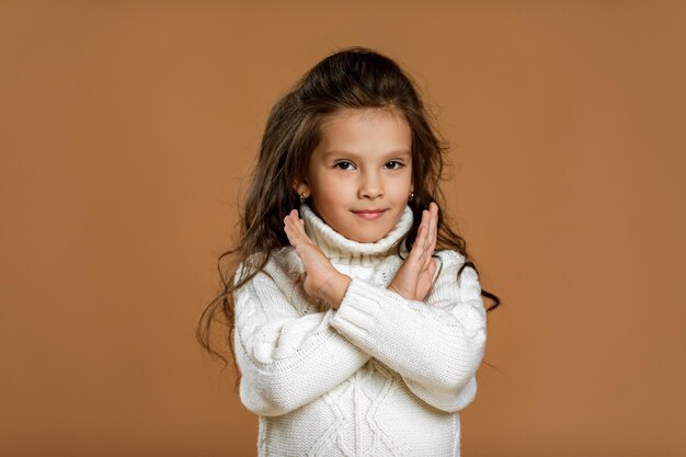 Bambina in maglione bianco che fa gesto di arresto