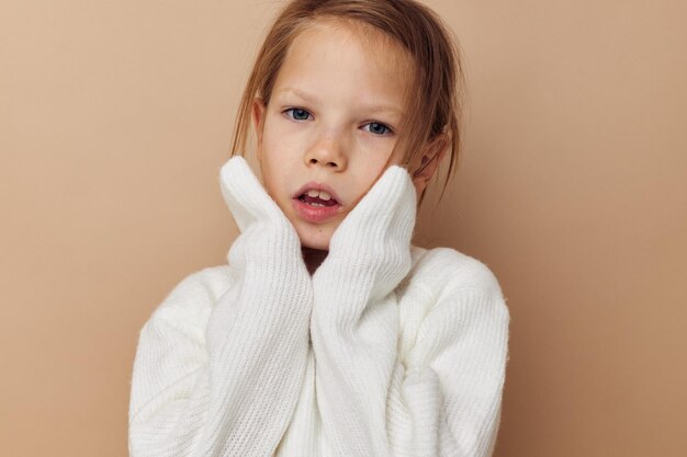 Bambina in maglione bianco in posa gesti con le mani infanzia inalterata