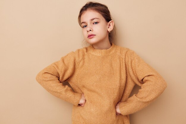 Bambina in maglione che posa lo stile di vita dei gesti delle mani inalterato